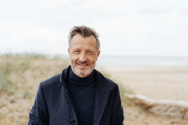 Mand på stranden i frakke